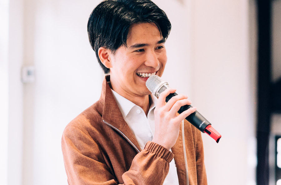 Daniel 拿著麥克風在課堂上分享